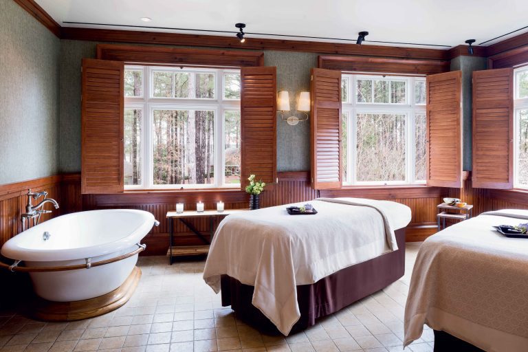 a room with a large tub and massage tables