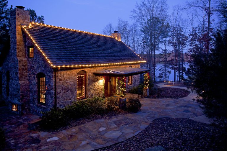 a stone house with Christmas lights