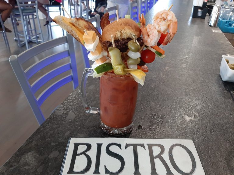 a bloody mary filled with shrimp, hamburger, grilled cheese, bacon and other items