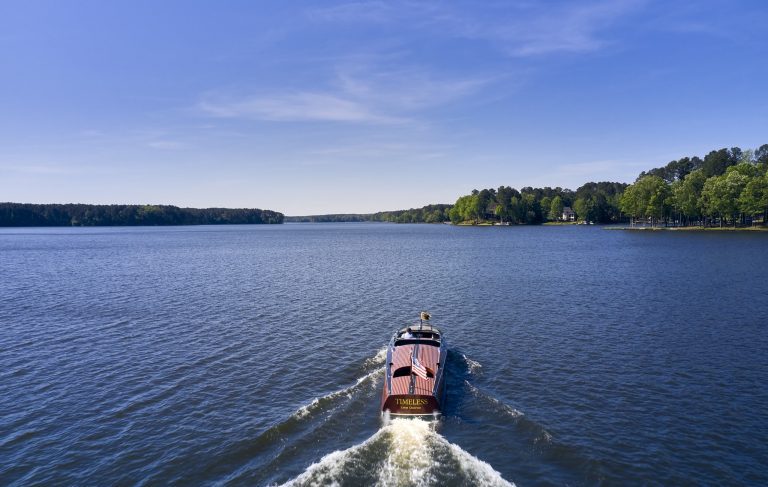 a boat cruising across lake Oconee on a beautiful day