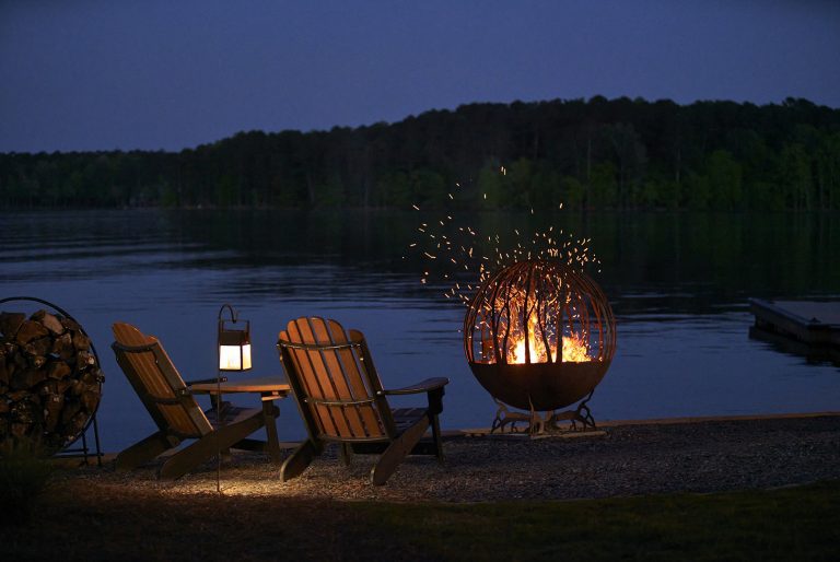 Adirondack chairs at night next to a fire pit